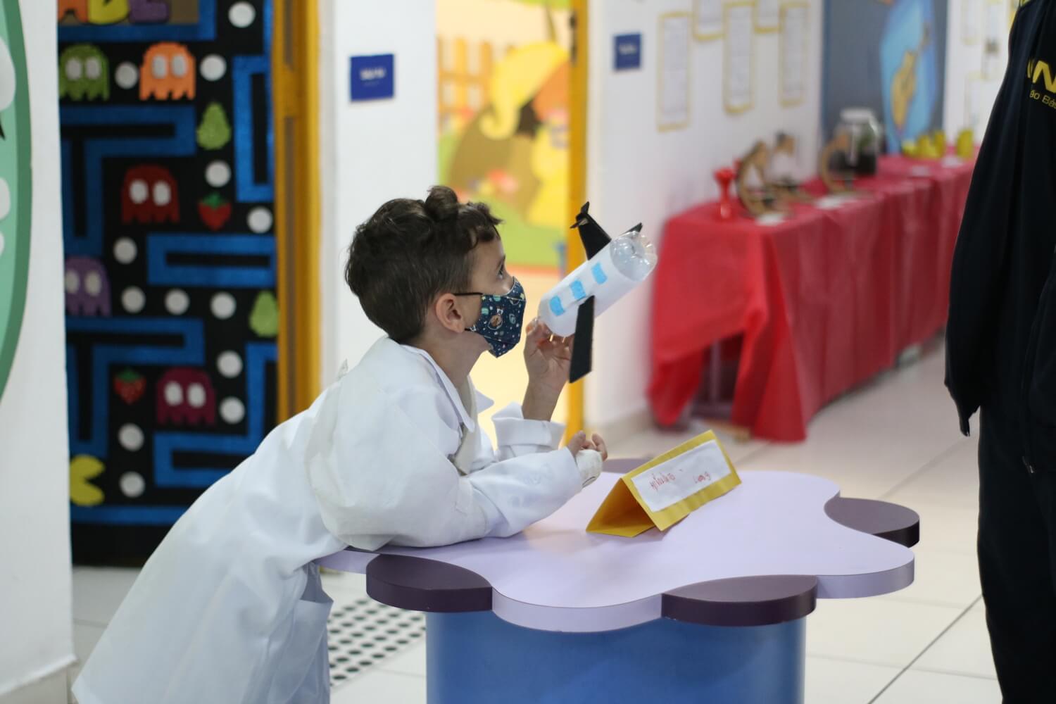 Menino mostrando um avião que ele criou