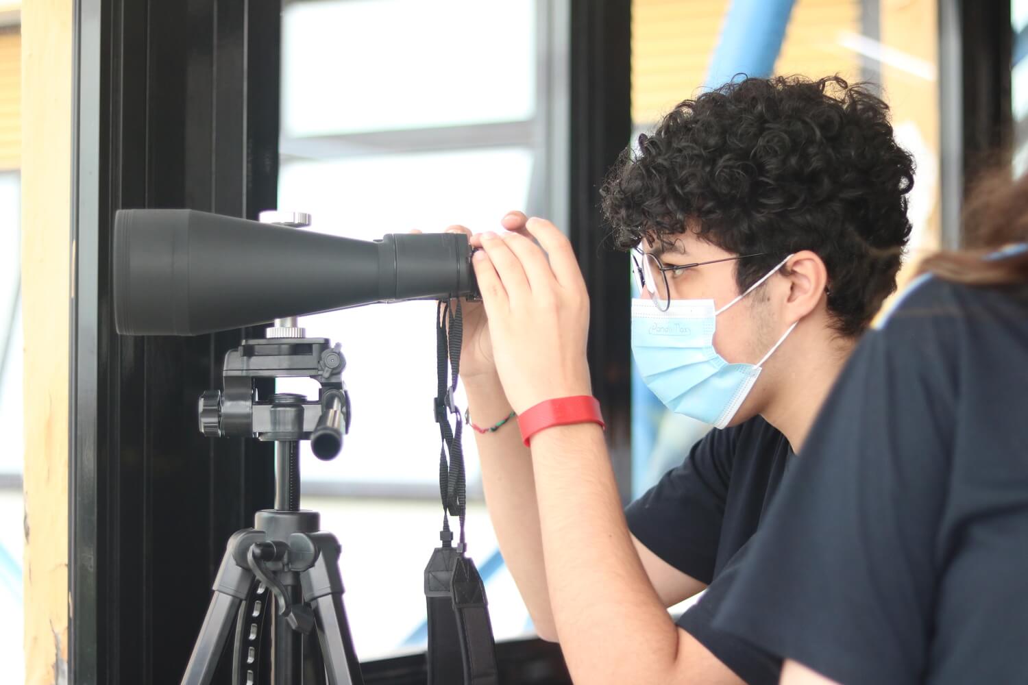 Menino utilizando um binóculos