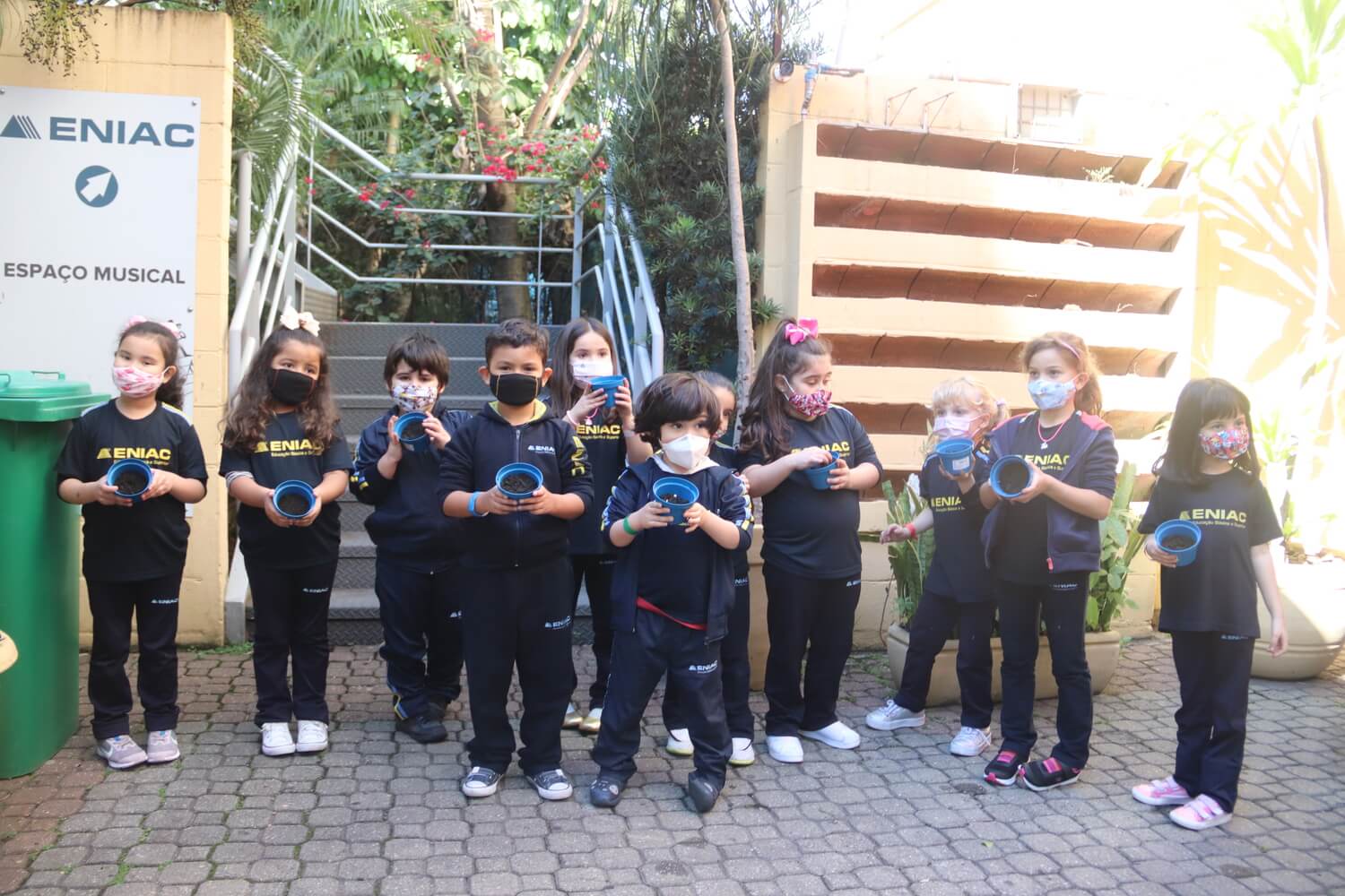 Crianças segurando um vaso para plantar