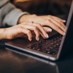 Mulher do curso de Faculdade de Pós-Graduação em Marketing Digital do eniac digitando no notebook