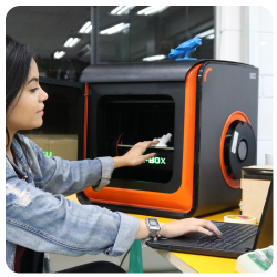 Mulher do curso de Engenharia de Produção do eniac utilizando uma impressora 3D 