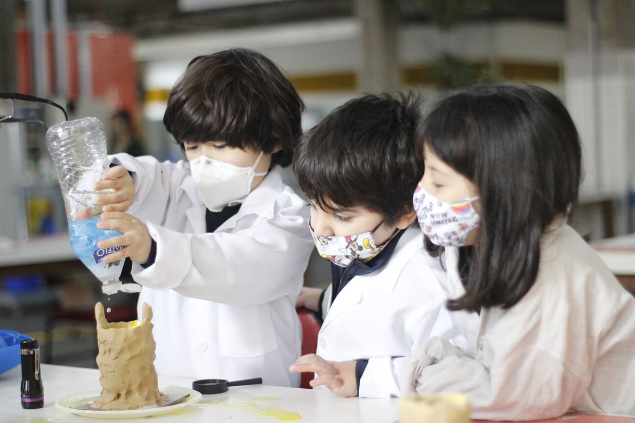 Três crianças desenvolvendo um projeto de ciências